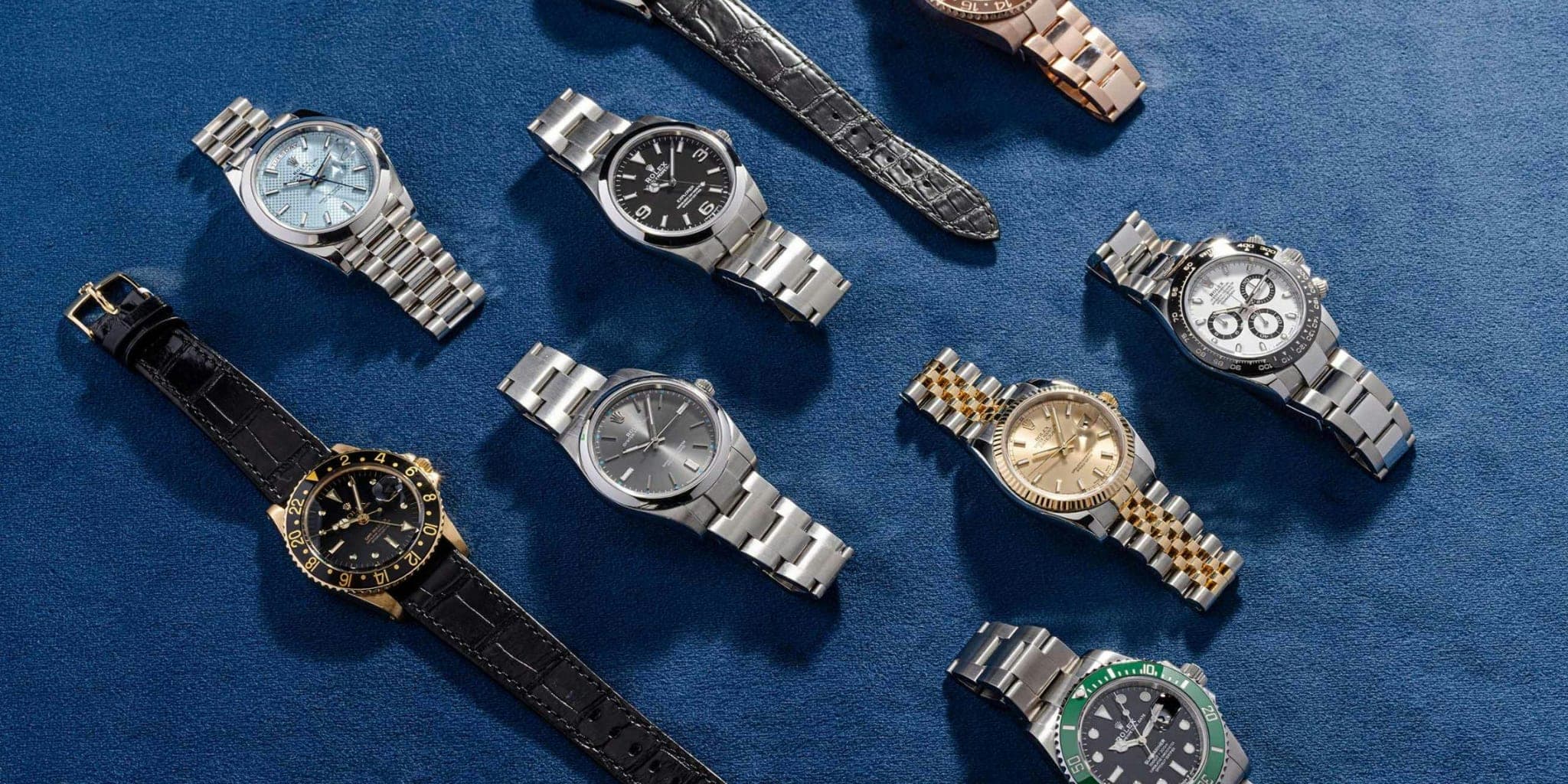 Pre-owned watches laid out on a blue cloth